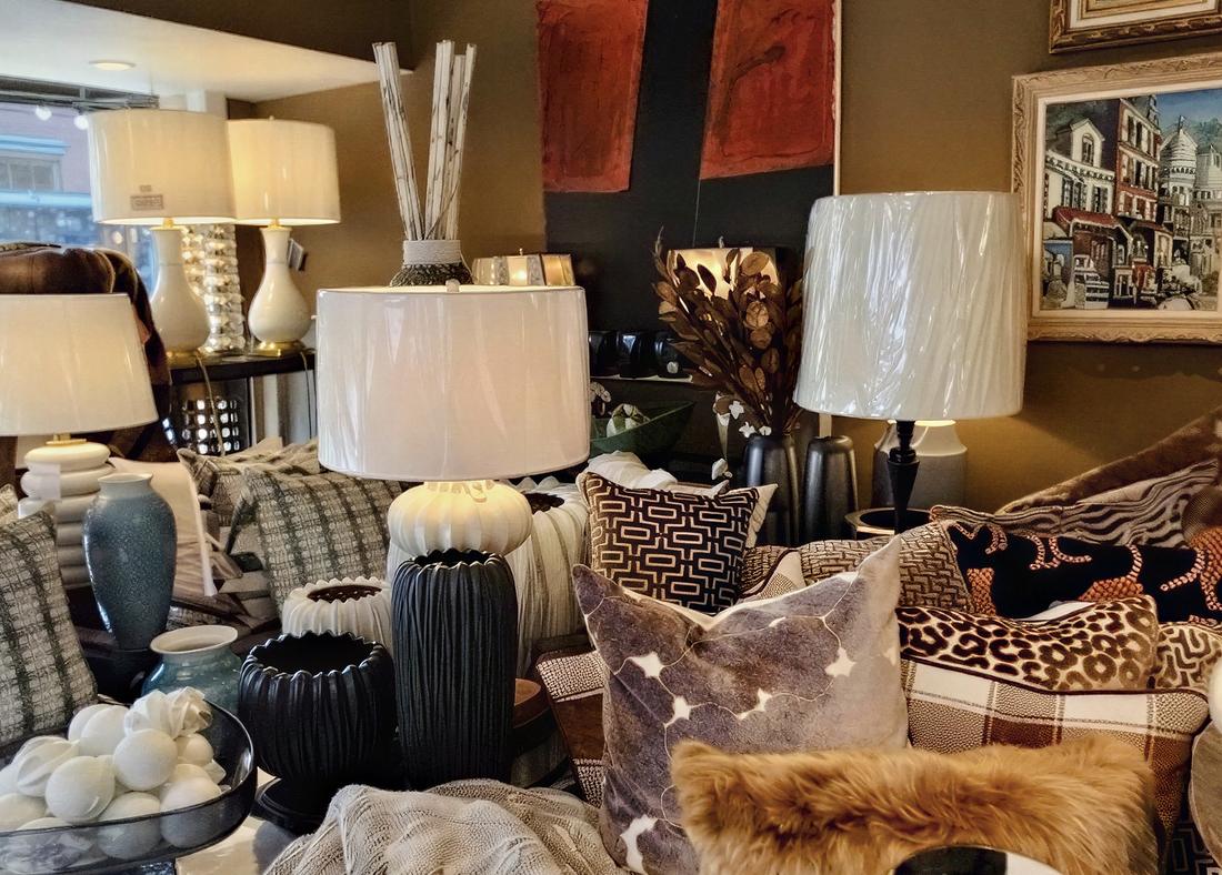 Lamps, patterned pillows and throws arranged across the shop floor.