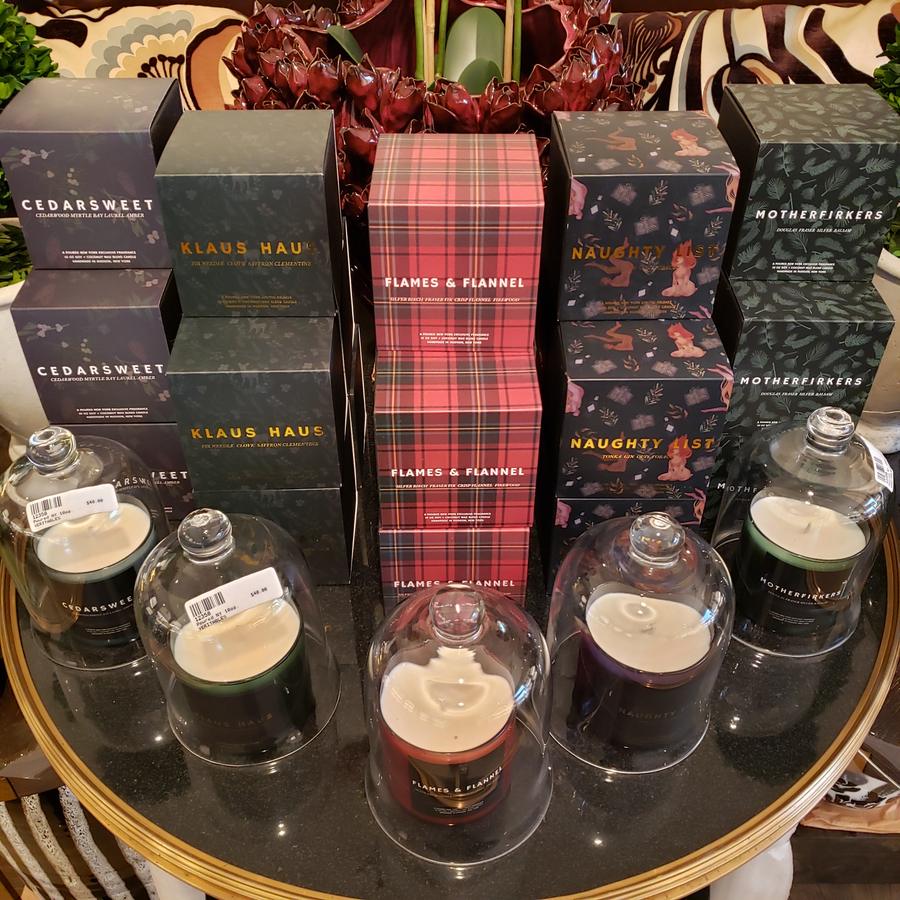 Boxed holiday candles in tartan and forest green on a glass tray.
